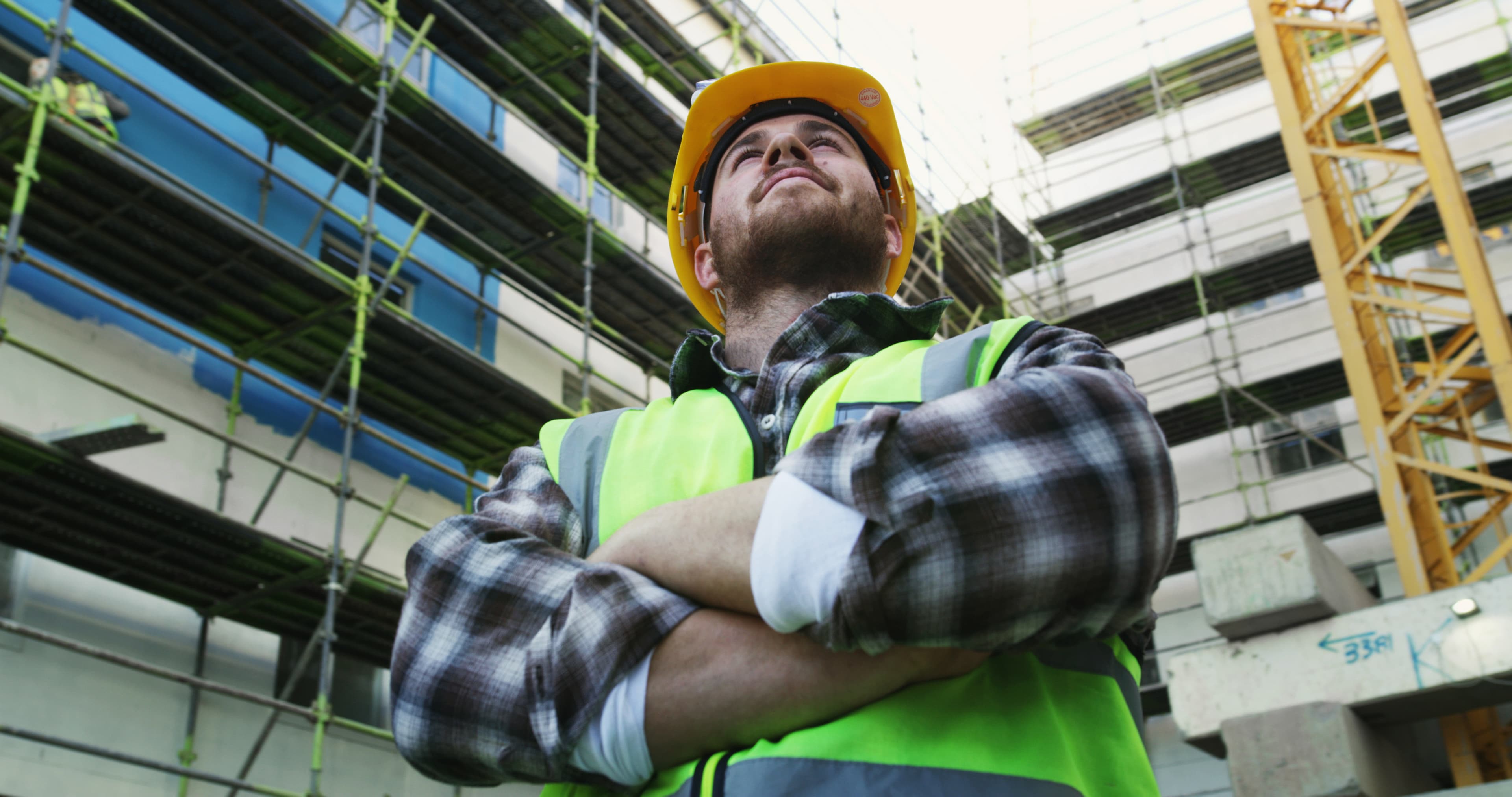 Gerüstbauer mit verschränkten Armen auf der Baustelle